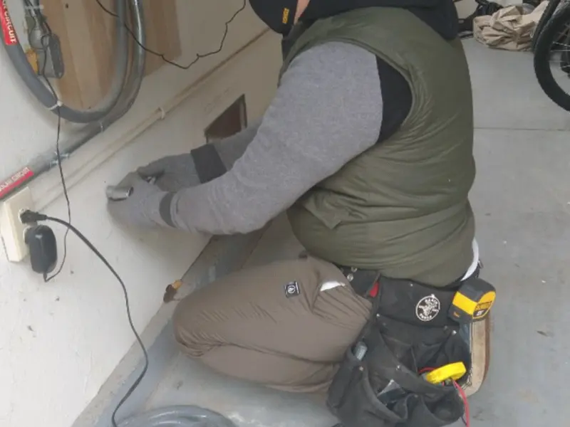Electrician performing outlet wiring in a Elsmere garage
